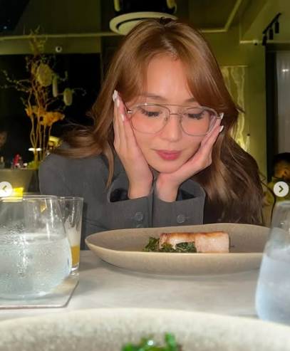 Kathryn Chandria admiring a bowl of freshly prepared food with a delighted expression.